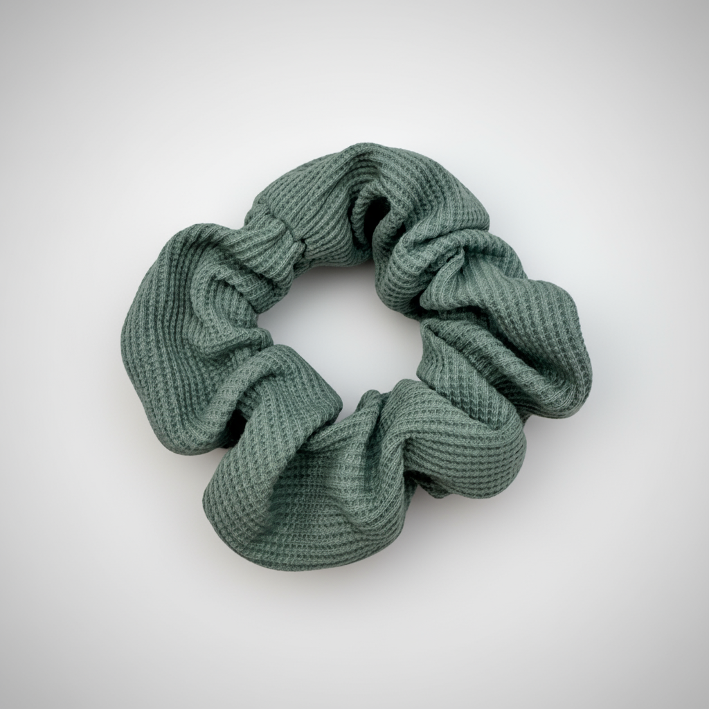 Textured sage green waffle knit scrunchie with visual soft volume, offering a gentle, secure hold for various hair types and styling preferences.
