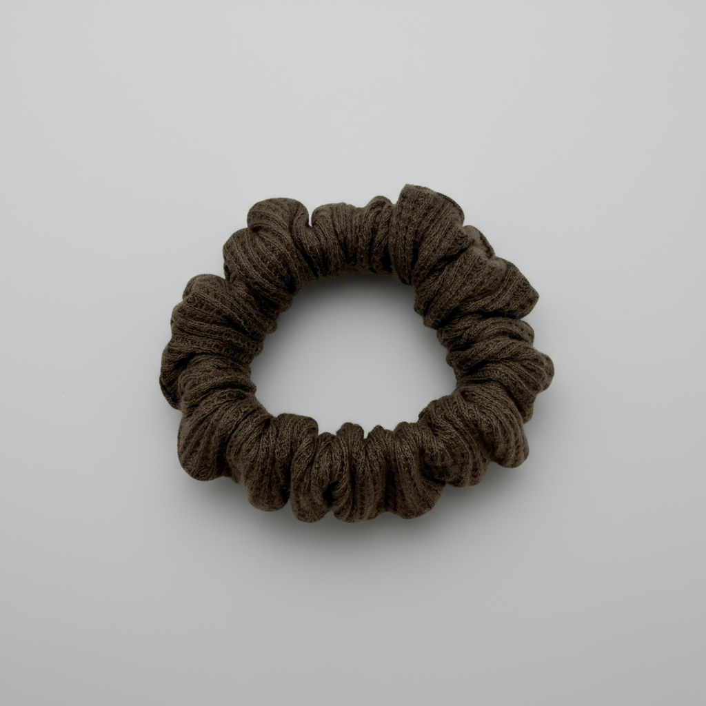 One brown waffle-knit cotton scrunchies.  The textured fabric features a soft, ribbed pattern, offering a cozy and voluminous look. Ideal for gentle hair styling across different hair types and preferences