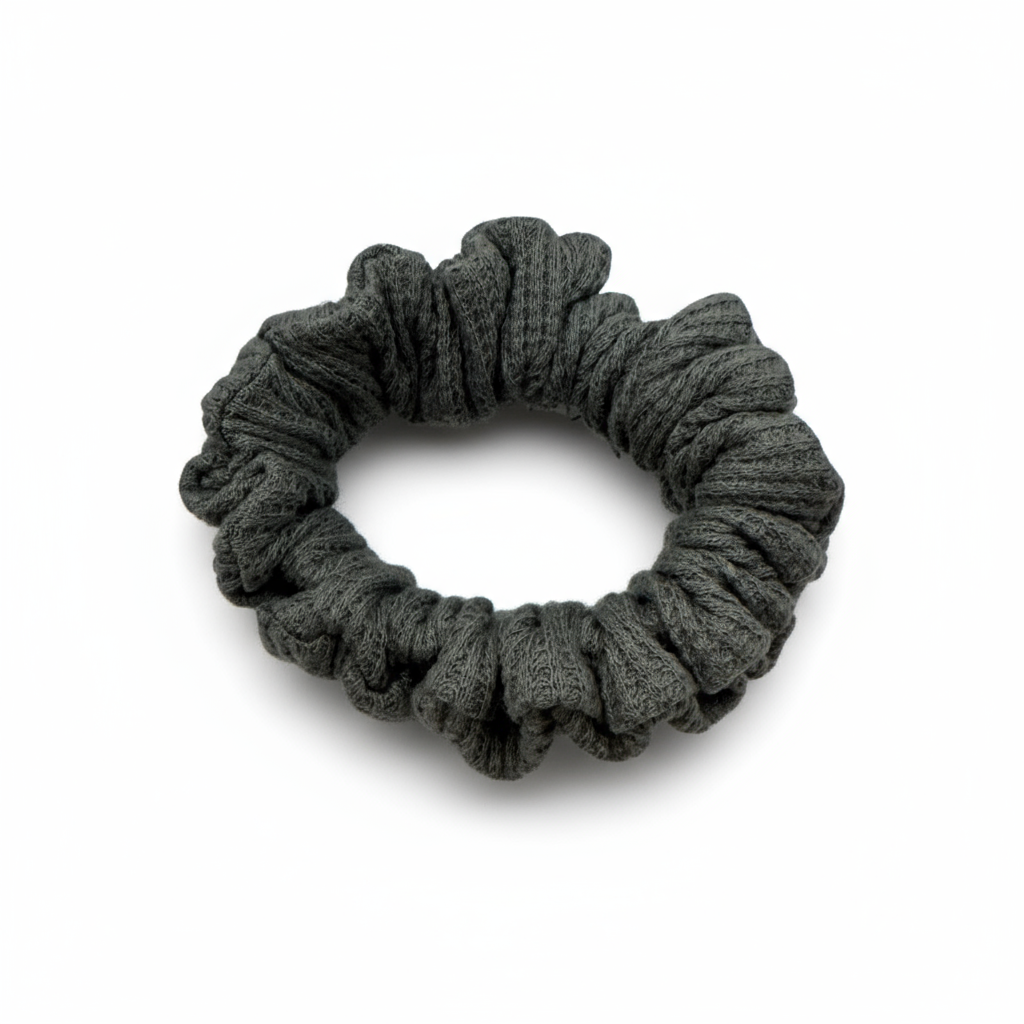 One grey waffle knit cotton scrunchie on a white background. Perfect for thick to medium hair, this scrunchie adds a touch of cozy soft elegance to any look.