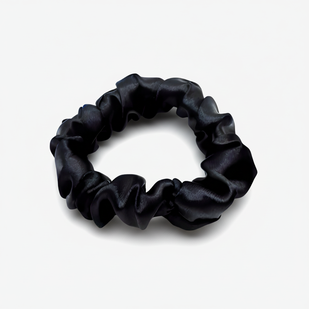 Black satin scrunchie with a smooth, glossy finish, gathered into soft ruffled folds. Handmade hair accessory designed for a gentle, secure hold and a sleek, timeless look.