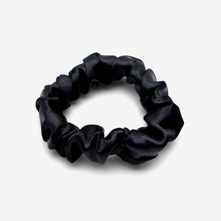 Black satin scrunchie with a smooth, glossy finish, gathered into soft ruffled folds. Handmade hair accessory designed for a gentle, secure hold and a sleek, timeless look.