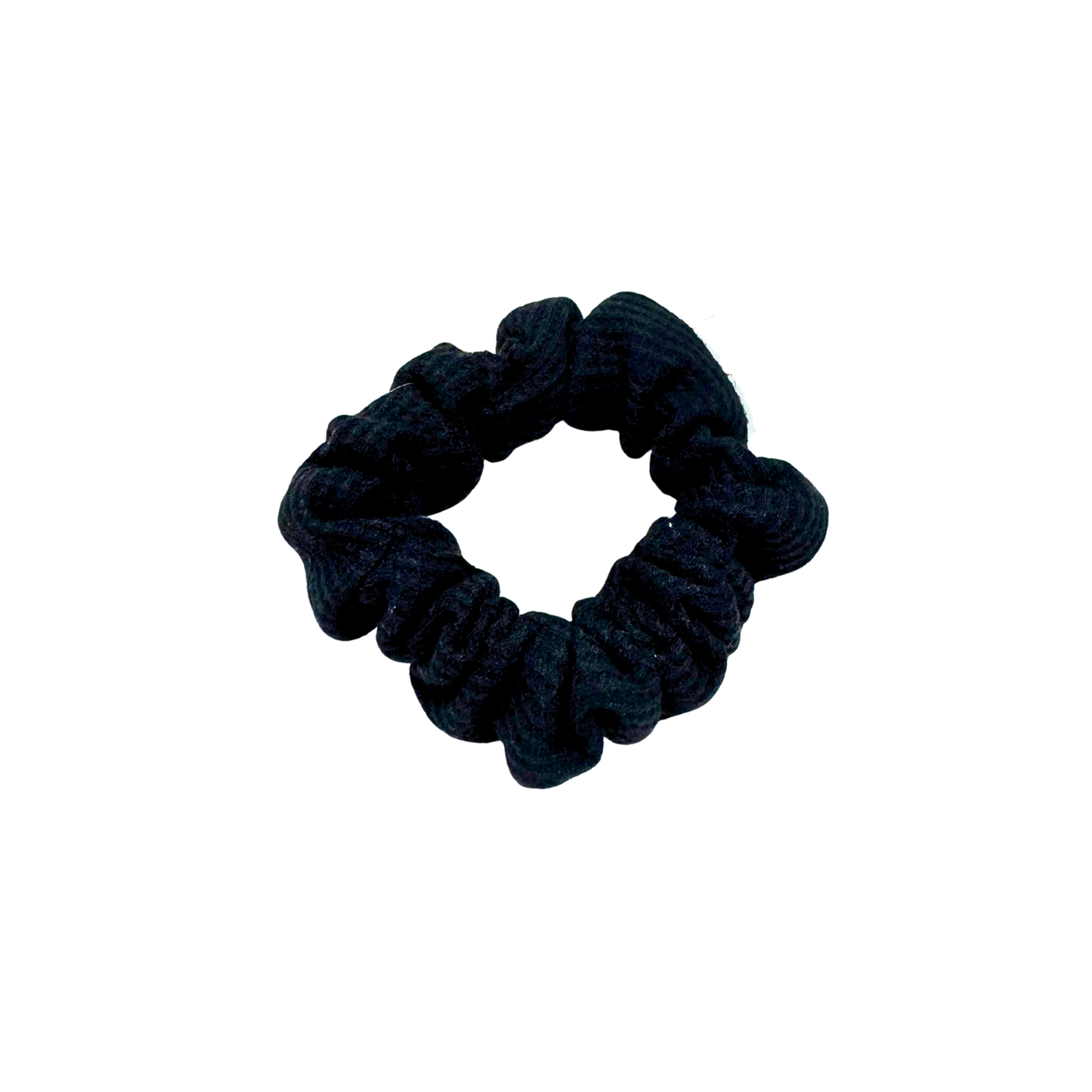 Black waffle knit cotton scrunchie with a gathered, ruffled texture, displayed against a neutral background. The ribbed fabric adds subtle dimension to the sleek black tone, offering a soft, secure hold ideal for everyday styling.