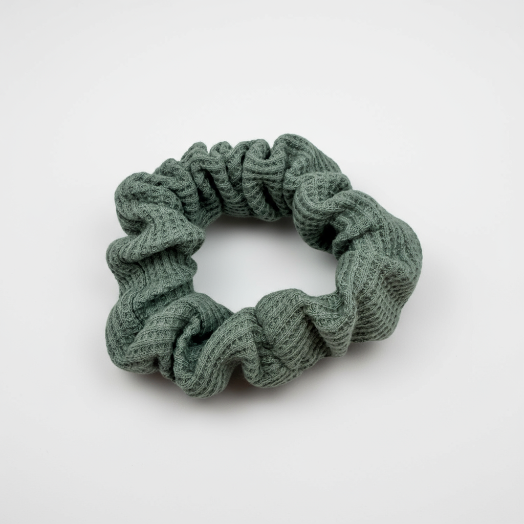 Textured sage green waffle knit scrunchie with visual soft volume, offering a gentle, secure hold for various hair types and styling preferences. 
