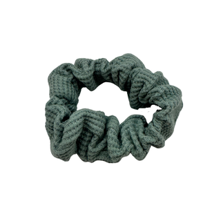 Textured sage green waffle knit scrunchie with visual soft volume, offering a gentle, secure hold for various hair types and styling preferences. 