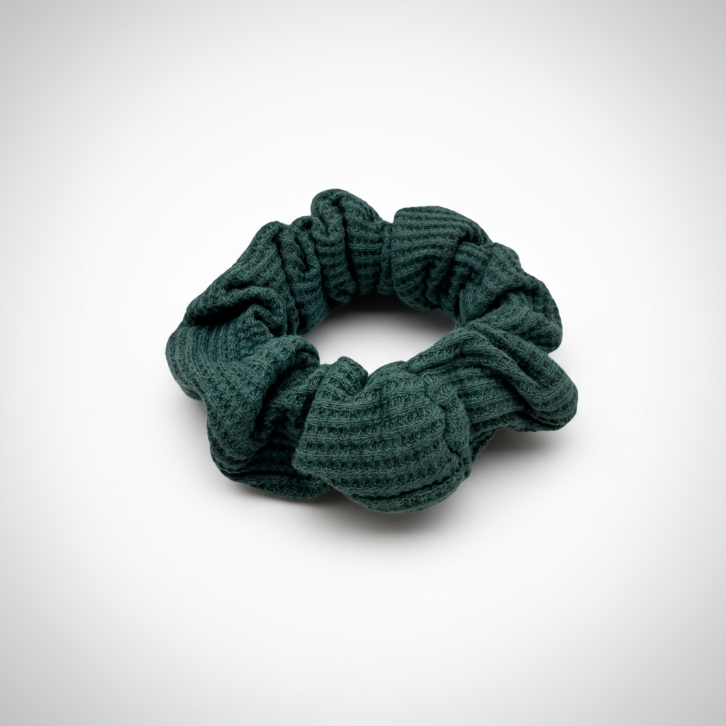 Teal textured scrunchie on a white background  The gathered, ribbed material creates soft volume and a cozy, tactile look