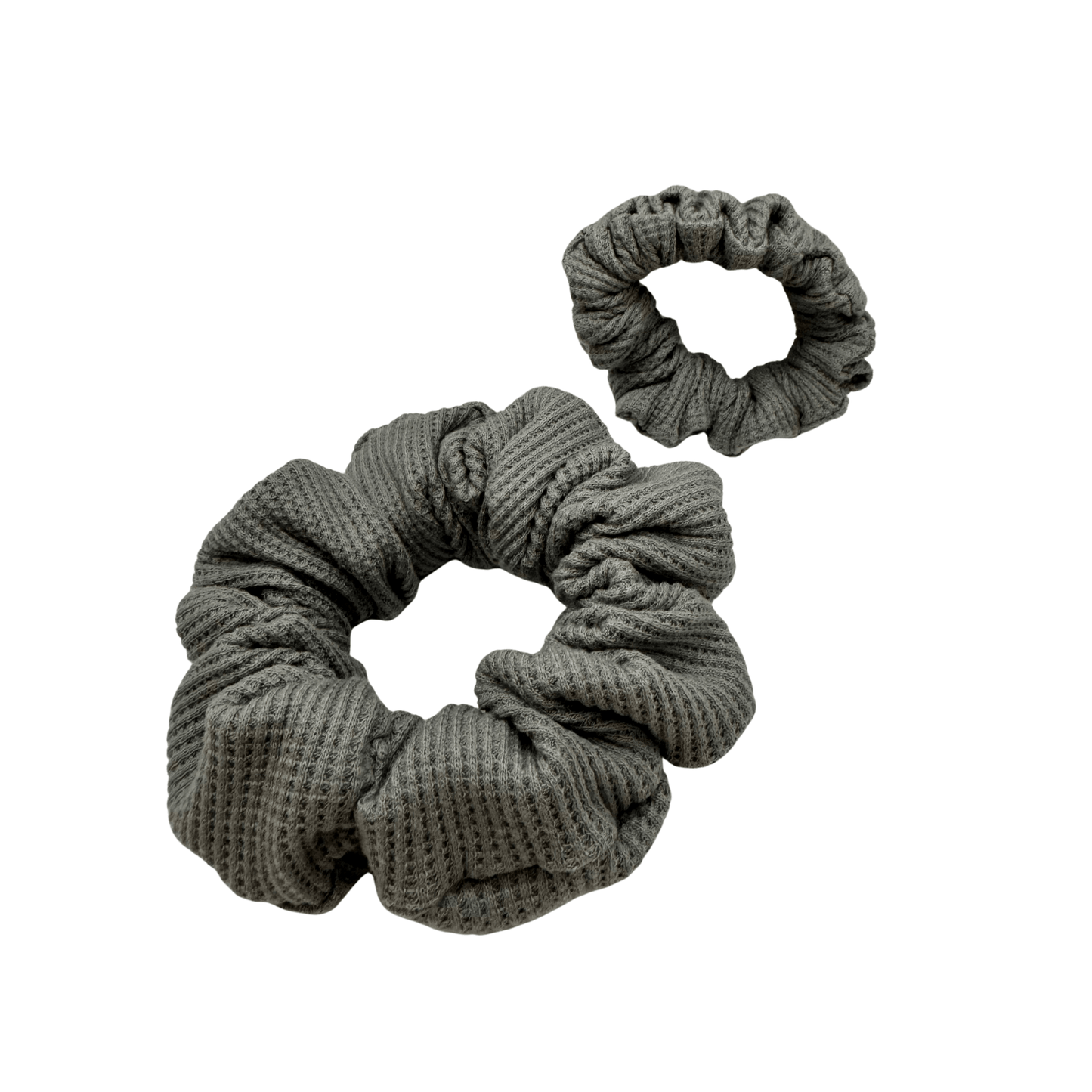 2 Grey waffle knit cotton scrunchies on a white background. Perfect for thick to medium hair, these scrunchies adds a touch of cozy soft elegance to any look.