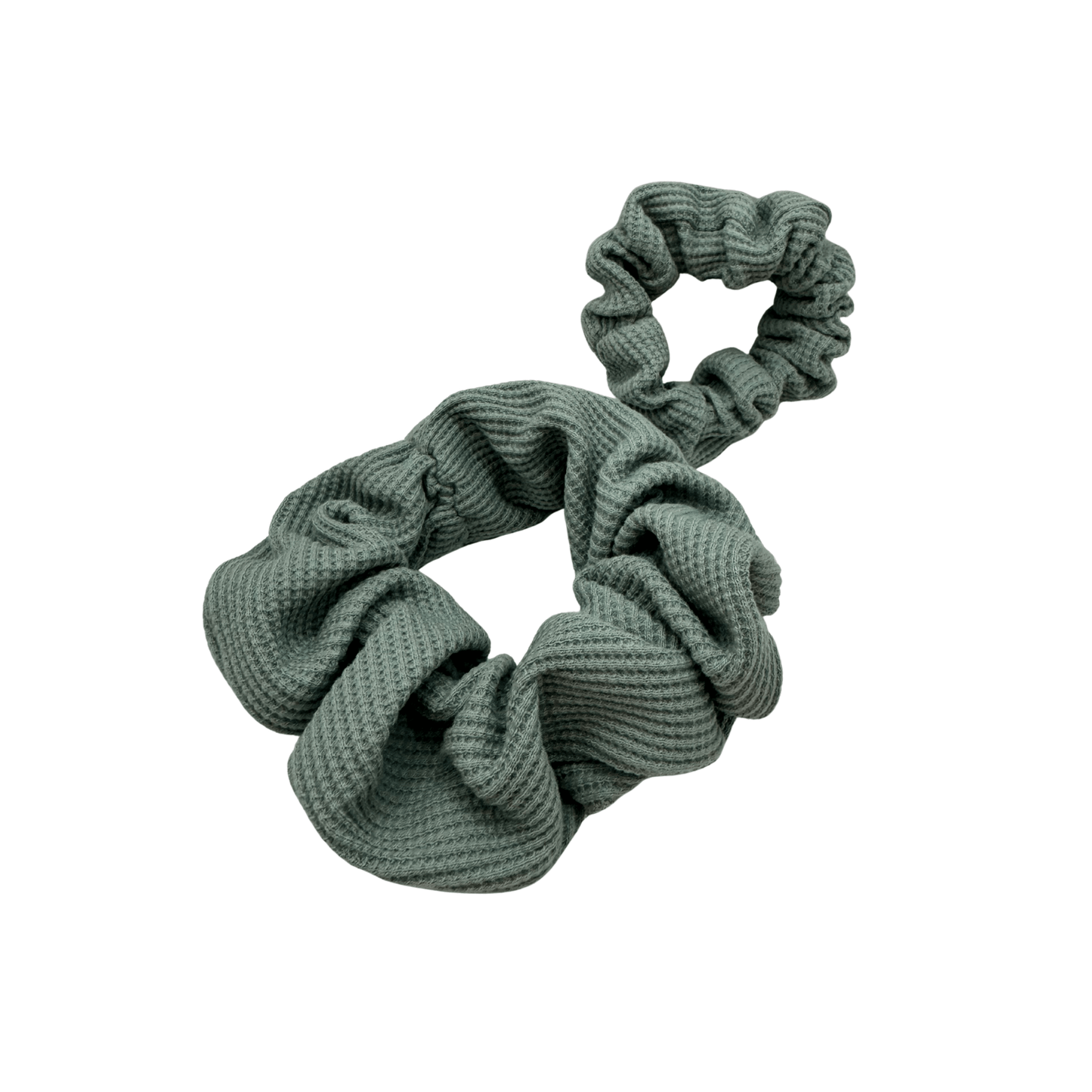 Textured sage green waffle knit scrunchie set featuring one large scrunchie and a smaller looped accent piece. The ribbed cotton fabric adds soft volume and visual interest, offering a gentle, secure hold for various hair types and styling preferences. 